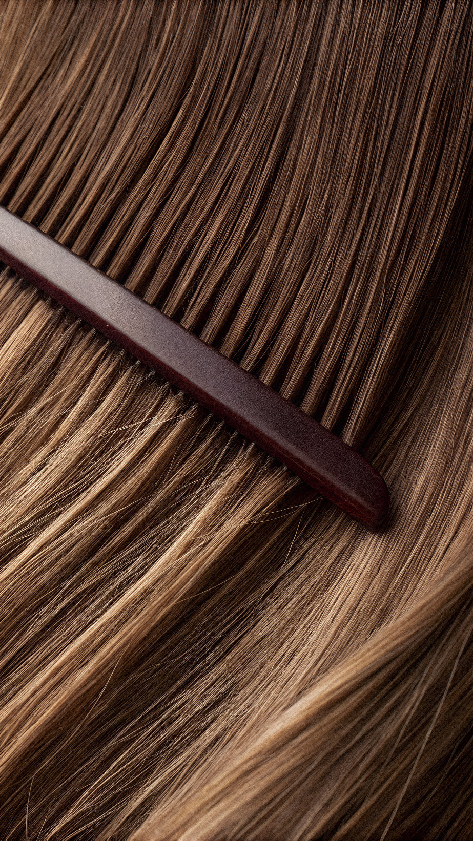 Kräftiges, glänzendes Haar wird mit einem Kamm durchgekämmt – gesundes Haarwachstum durch Kollagen-Supplementierung