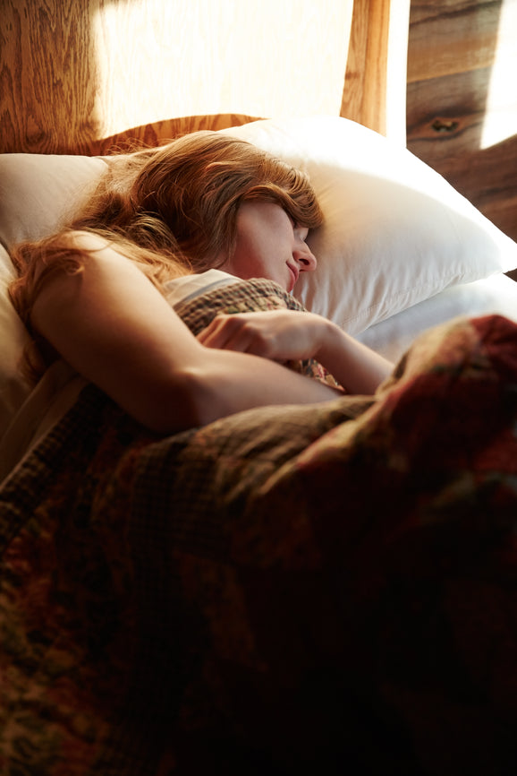 Müde Frau mit Antriebslosigkeit und Erschöpfung im Bett durch Dopamin-Mangel