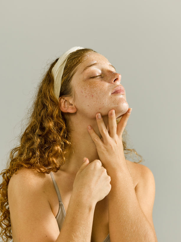 Rosazea Symptome im Gesicht – typische Rötungen und erweiterte Äderchen auf den Wangen bei einer Frau, die Rosazea natürlich behandeln möchtenfter Gesichtspflege in warmem Licht